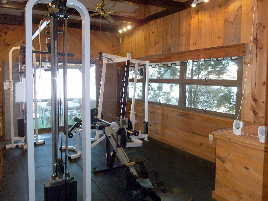 Exercise room with professional quality equipment overlooks lake next to screened porch